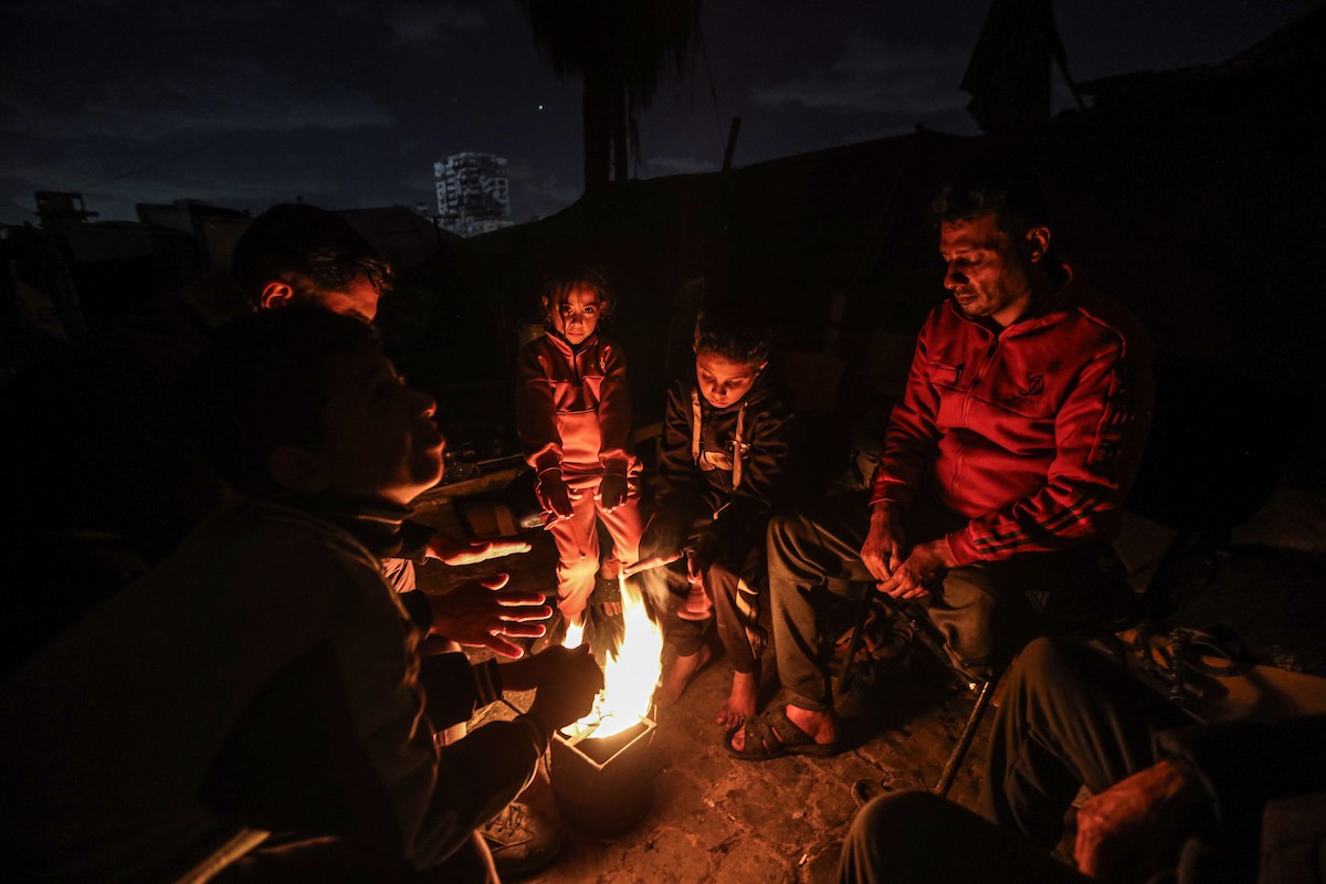 عائلات نازحة تتجمع حول النار للتدفئة في مدينة غزة في ظل الأجواء الباردة، 30 ديسمبر/كانون الأول 2025. تصوير: عمر أشتوي