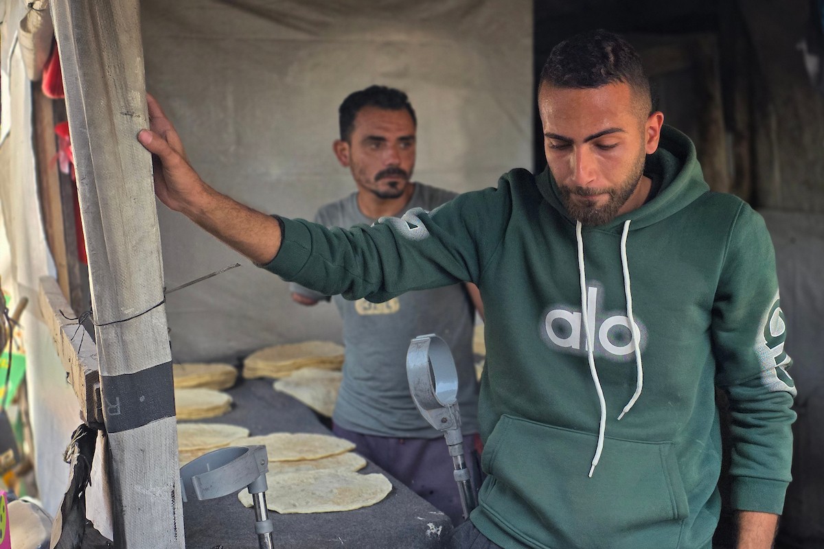 الفلسطيني محمد قحمان يعيد افتتاح مخبز تقليدي وسط أنقاض مدينة حمد غرب خان يونس، ويعمل جنباً إلى جنب مع أبنائه وصهره، وجميعهم من مبتوري الأطراف، 21 يناير/كانون الثاني 2026  . صورة: طارق محمد