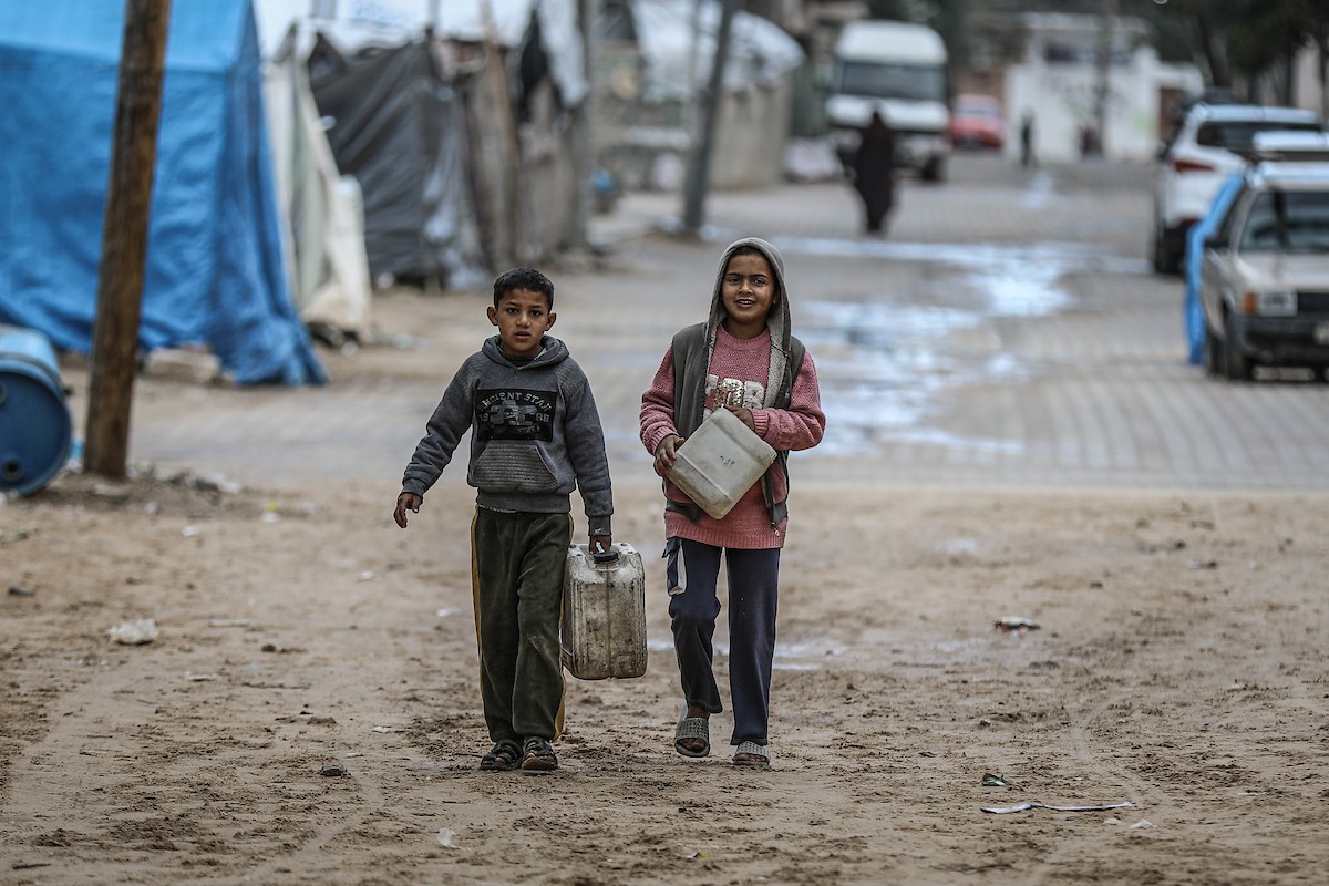 يملأ الفلسطينيون خزاناتهم بالمياه التي توزعها صهاريج المياه، وينقلونها إلى خيامهم في مخيم النصيرات وسط قطاع غزة، حيث تفاقمت أزمة المياه نتيجة الأضرار الجسيمة التي لحقت بالبنية التحتية جراء الهجمات الإسرائيلية، 29 يناير/كانون الثاني 2026. صورة: رمزي أبو عامر