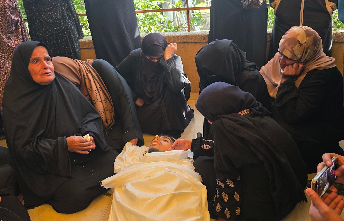 فلسطينيون يودعون جثمان الشاب محمد أسامة عمران، البالغ من العمر 19 عامًا، في مجمع ناصر الطبي بخان يونس، بعد أن استشهد برصاص القوات الإسرائيلية في وسط خان يونس، جنوب قطاع غزة. 29 يناير/كانون الثاني 2026. تصوير: طارق محمد (APA Images)