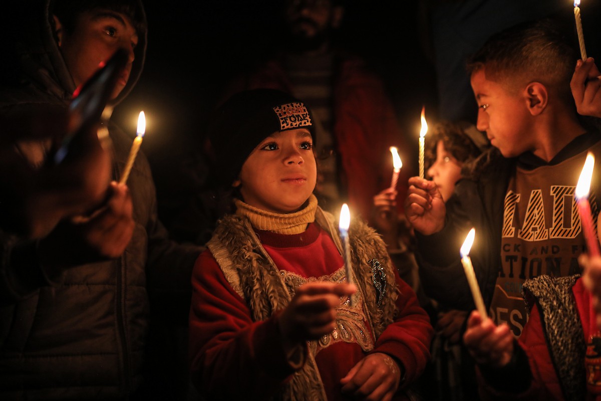 أطفال في وقفة احتجاجية في مخيم الشاطئ غرب مدينة غزة ليلة رأس السنة الميلادية 2026، 1 يناير/كانون الثاني 2026. تصوير: عمر أشتوي