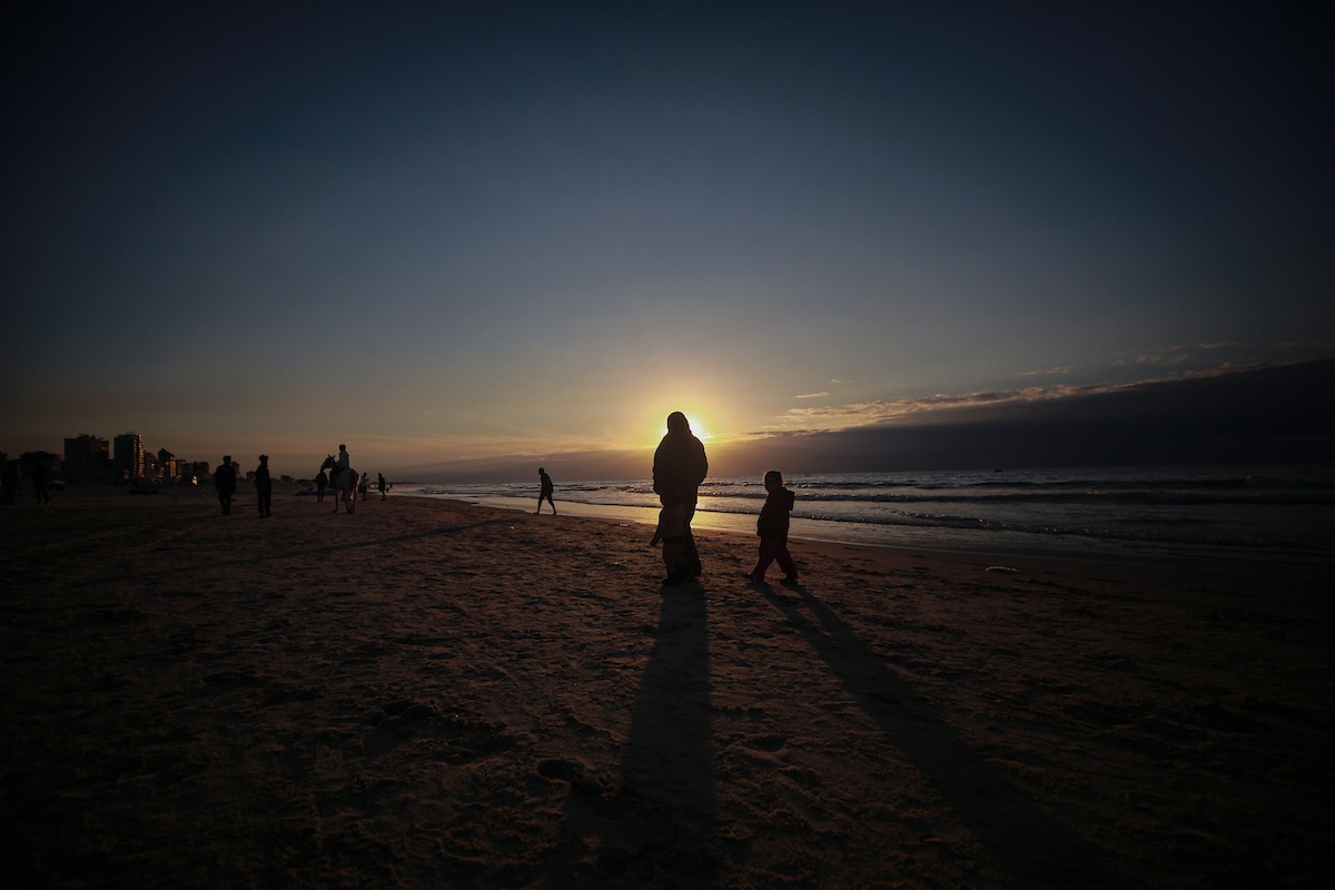 يقضي الفلسطينيون أوقاتهم على شاطئ البحر عند غروب الشمس في مدينة غزة، 16 يناير/كانون الثاني 2026. تصوير: عمر أشتوي