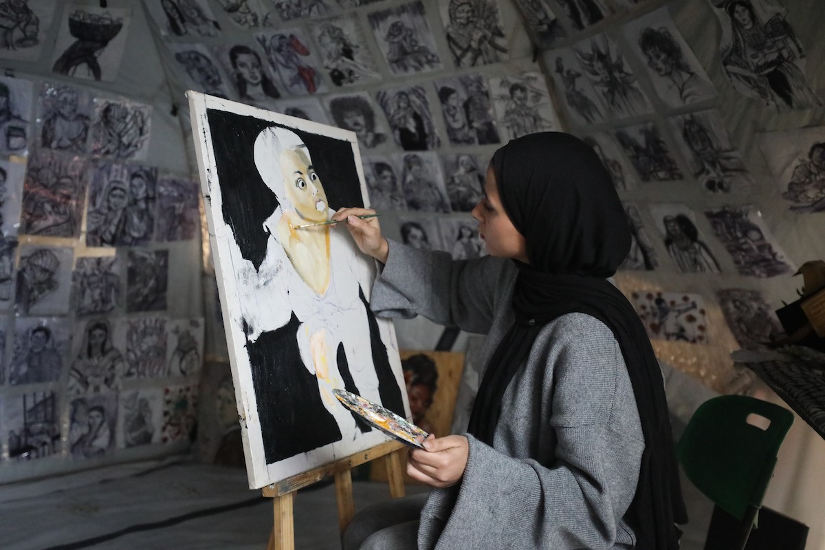 الفلسطينية مرَح خالد الزعانين (18 عاما) تحول خيمة نزوحها في مدينة غزة إلى معرض فني، 28 يناير/كانون الثاني 2026. تصوير: عمر أشتوي