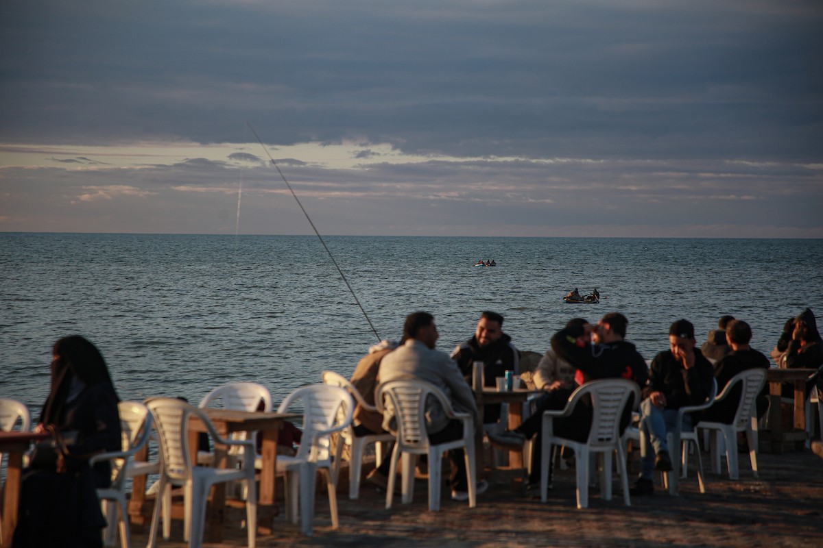 يقضي الفلسطينيون أوقاتهم على شاطئ البحر عند غروب الشمس في مدينة غزة، 16 يناير/كانون الثاني 2026. تصوير: عمر أشتوي