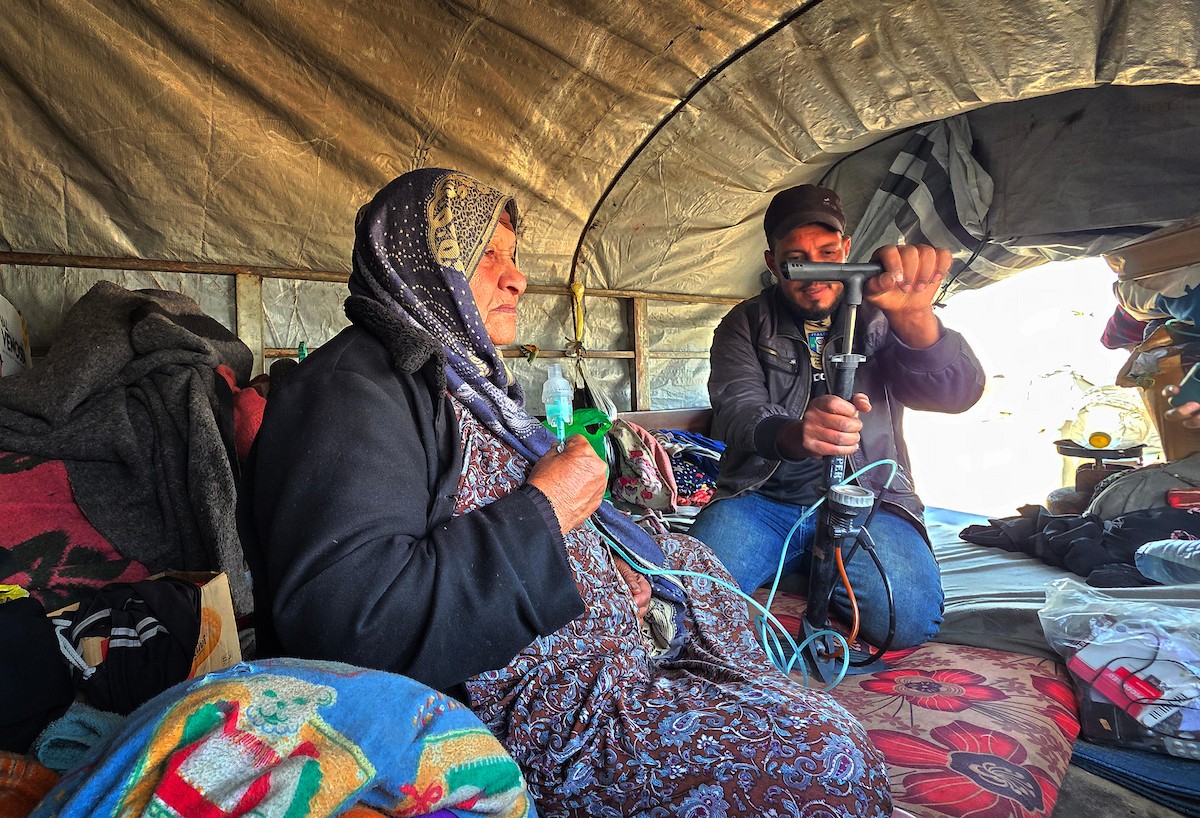 يعيش الفلسطيني سامي أبو سعادة مع والدته داخل عربة جرار، ويستخدم مضخة نفخ مطاطية لمساعدة والدته التي تعاني من صعوبة في التنفس. خان يونس، جنوب قطاع غزة، 7 يناير/كانون الثاني 2026، صورة: طارق محمد