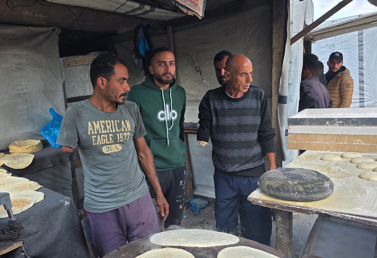 الفلسطيني محمد قحمان يعيد افتتاح مخبز تقليدي وسط أنقاض مدينة حمد غرب خان يونس، ويعمل جنباً إلى جنب مع أبنائه وصهره، وجميعهم من مبتوري الأطراف، 21 يناير/كانون الثاني 2026  . صورة: طارق محمد