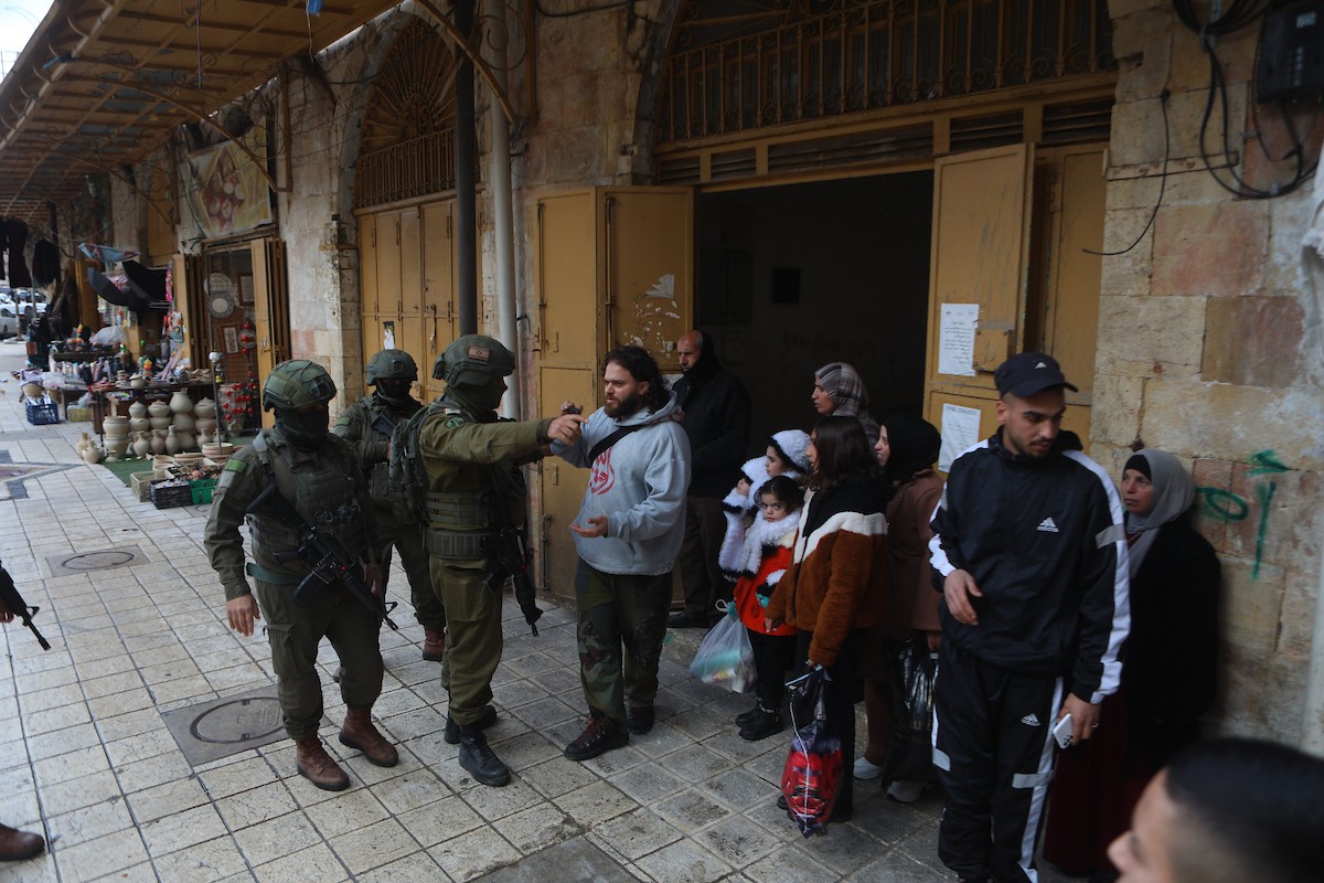 جنود إسرائيليون يقفون في دورية حراسة خلال جولة أسبوعية للمستوطنين في مدينة الخليل، جنوب الضفة الغربية ، 10 يناير/كانون الثاني 2026. تصوير: مأمون وزواز
