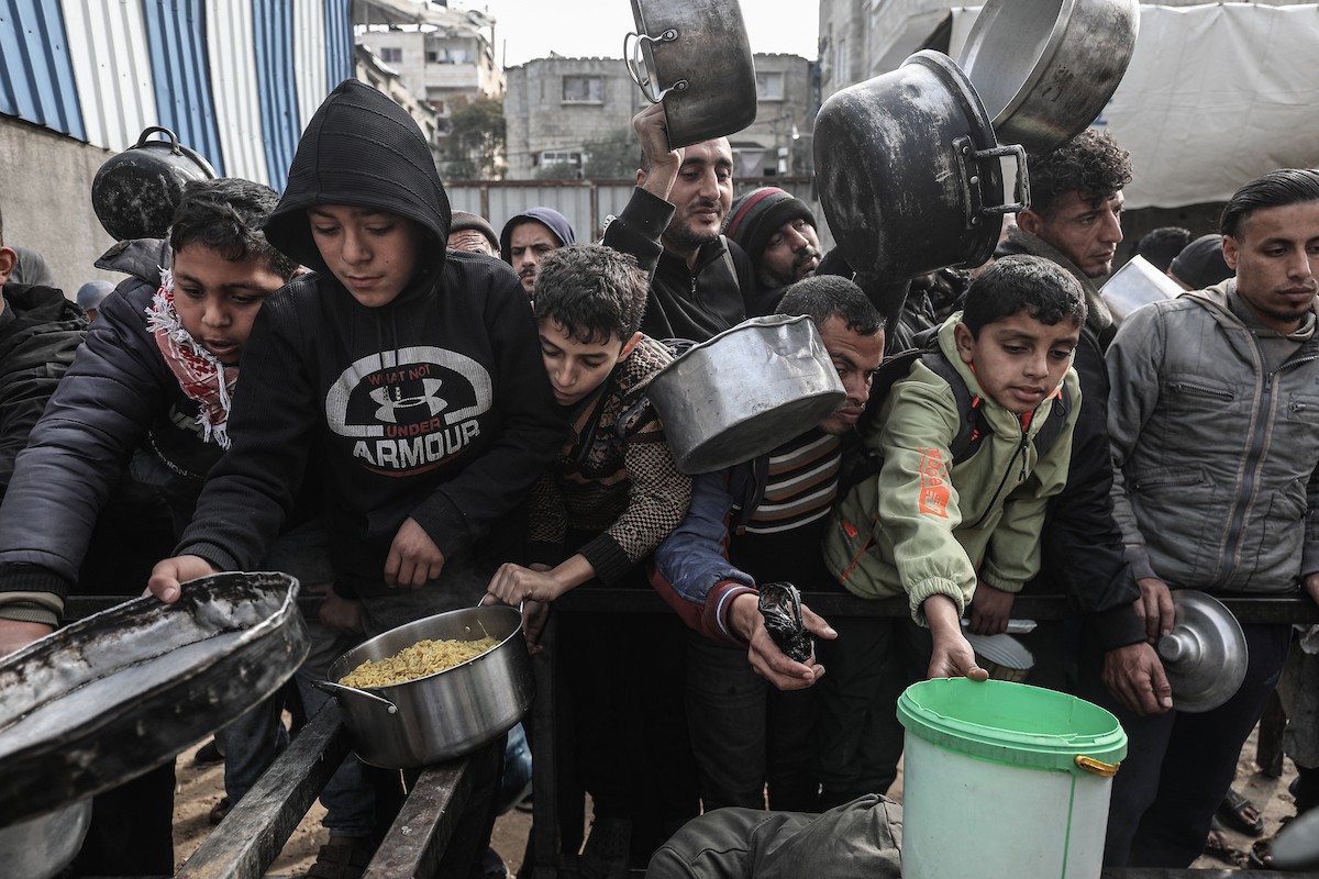 تجمع فلسطينيون نازحون داخلياً في مطبخ خيري لتلقي حصص غذائية محدودة وسط نقص حاد في الغذاء، في مخيم النصيرات للاجئين وسط قطاع غزة، 21 يناير/كانون الثاني 2026. صورة: معز صالحي