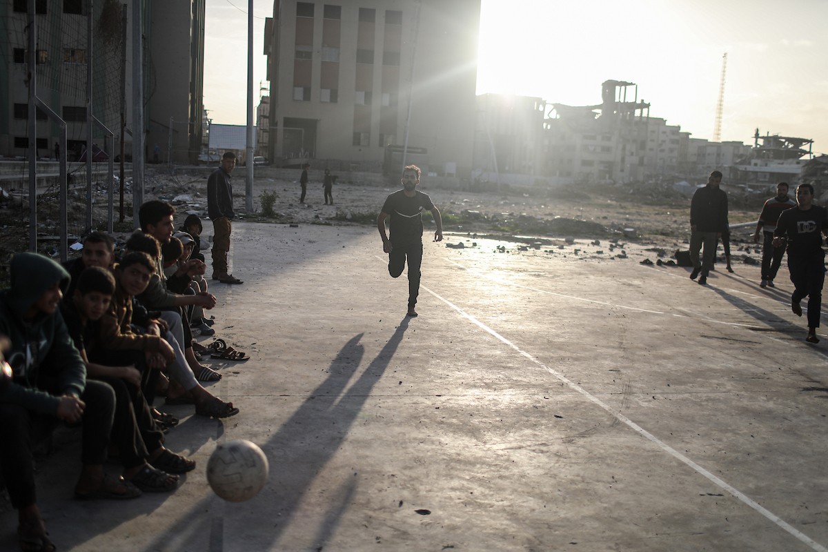   شبان فلسطينيون نازحون يلعبون كرة القدم في ملعب مدمر بمدينة غزة، في 10 يناير/كانون الثاني 2026. صورة: عمر أشتوي