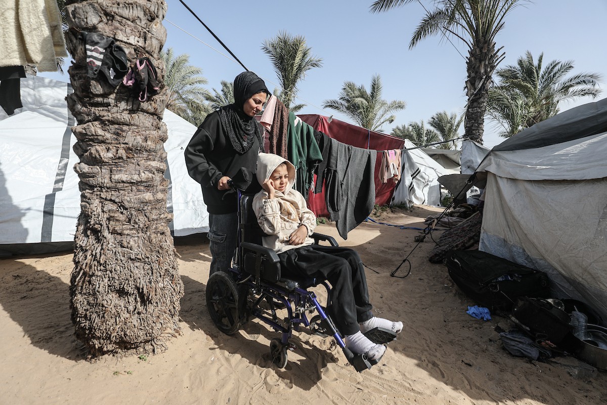 الطفل سيف رامي حجازي (13 عاما) أُصيب بشلل كامل وفشل كلوي إثر قصف إسرائيلي لخيمة عائلته، وتتولى والدته رعايته في ظروف إنسانية بالغة الصعوبة بمخيم المغازي، وسط قطاع غزة، 30 يناير/كانون الثاني 2026. صورة: معز صالحي