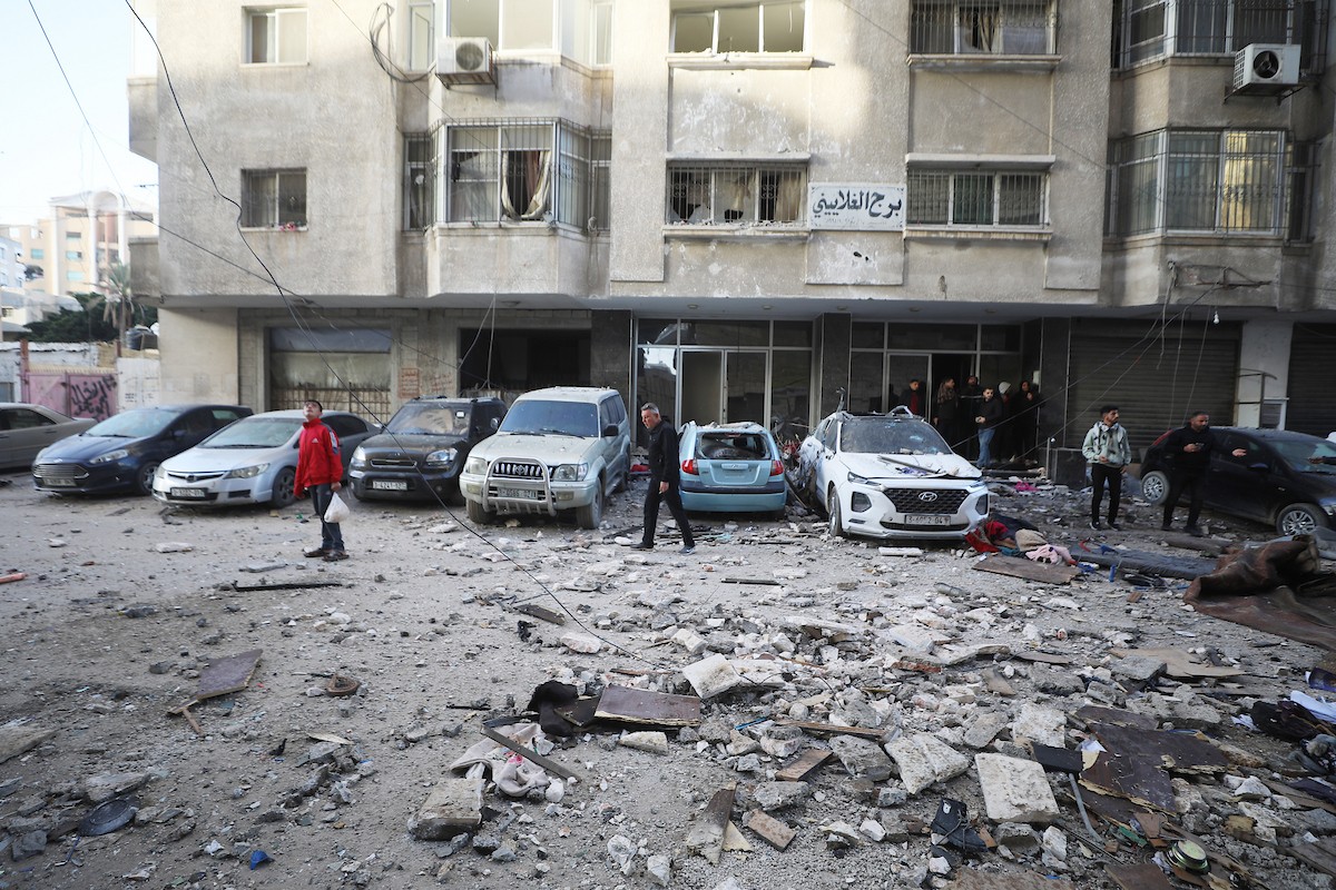 فلسطينيون يمرون أمام مبنى سكني تضرر جراء غارة عسكرية إسرائيلية أسفرت عن سقوط عدد من الضحايا في مدينة غزة، السبت 31 يناير/كانون الثاني 2026. صورة: عمر أشتوي