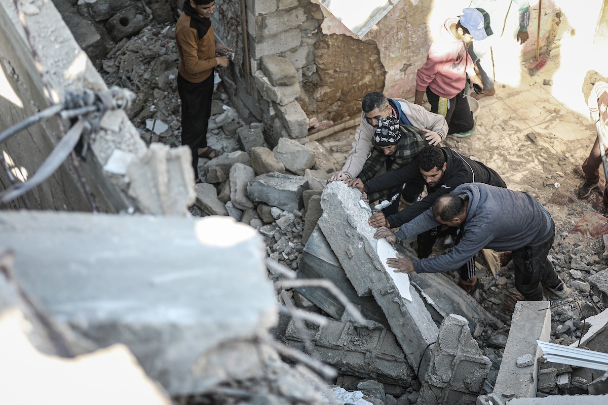 فلسطينيون يتفقدون منزلاً (تضرر سابقاً جراء غارة جوية إسرائيلية) انهار على سكانه، ما أسفر عن وفاة رجل ونجله الصغير في مخيم المغازي للاجئين وسط قطاع غزة، 5 يناير/كانون الثاني 2026. صورة: رمزي أبو عامر