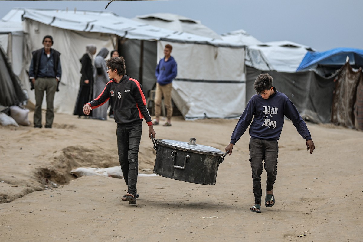 يتفقد فلسطينيون نازحون خيامهم بعد أن تضررت بشدة جراء عاصفة هوائية قوية ضربت مخيمًا للنازحين وسط قطاع غزة. 22 يناير/كانون الثاني 2026. تصوير: رمزي أبو عامر