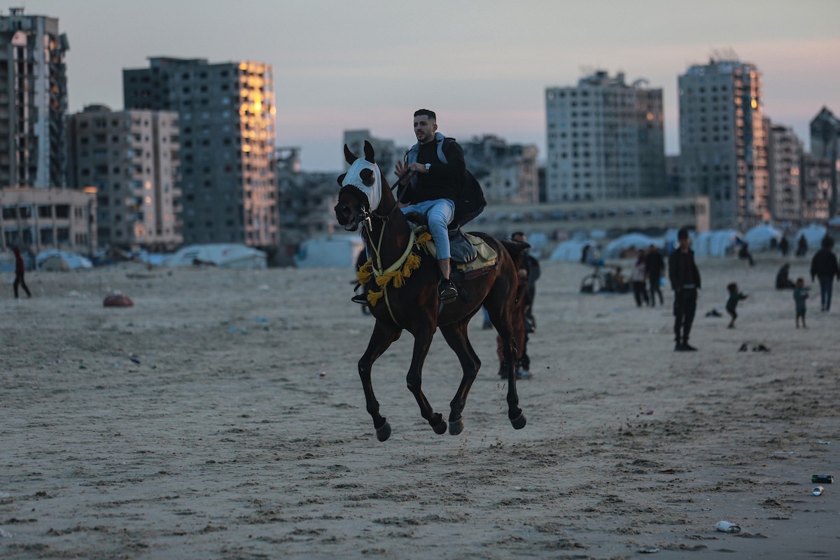 يقضي الفلسطينيون أوقاتهم على شاطئ البحر عند غروب الشمس في مدينة غزة، 16 يناير/كانون الثاني 2026. تصوير: عمر أشتوي