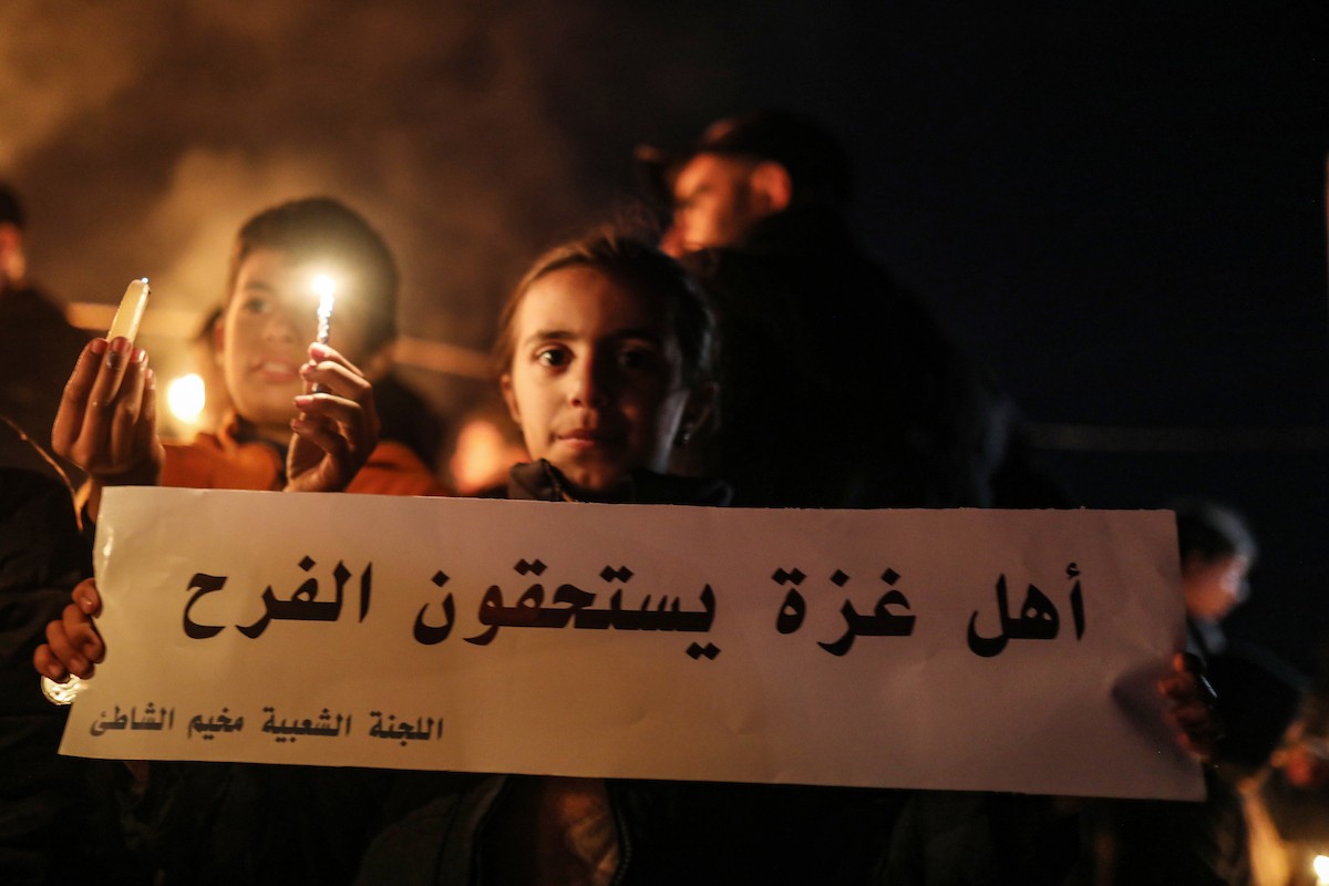 أطفال في وقفة احتجاجية في مخيم الشاطئ غرب مدينة غزة ليلة رأس السنة الميلادية 2026، 1 يناير/كانون الثاني 2026. تصوير: عمر أشتوي