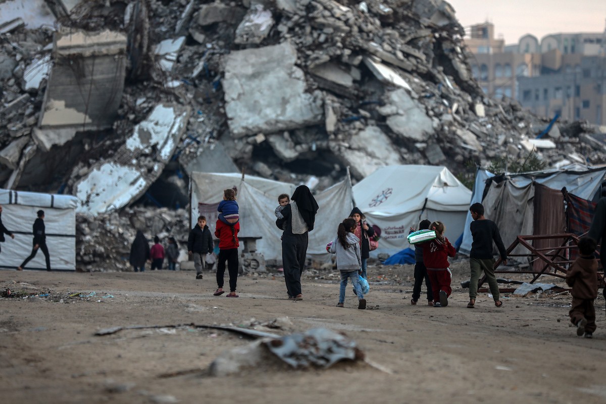 يسير فلسطينيون في شوارع مدينة غزة، وسط الأنقاض والدمار الذي خلفه الصراع الدائر، في 10 يناير/كانون الثاني 2026، بينما تستمر الحياة اليومية في ظل ظروف صعبة. صورة: عمر أشتوي