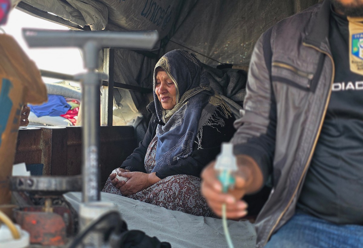 يعيش الفلسطيني سامي أبو سعادة مع والدته داخل عربة جرار، ويستخدم مضخة نفخ مطاطية لمساعدة والدته التي تعاني من صعوبة في التنفس. خان يونس، جنوب قطاع غزة، 7 يناير/كانون الثاني 2026، صورة: طارق محمد