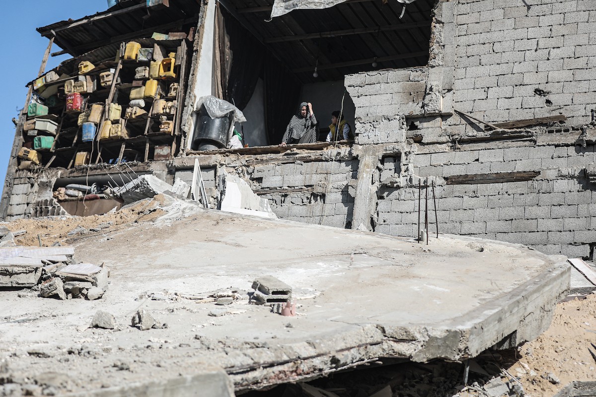 فلسطينيون يتفقدون منزلاً (تضرر سابقاً جراء غارة جوية إسرائيلية) انهار على سكانه، ما أسفر عن وفاة رجل ونجله الصغير في مخيم المغازي للاجئين وسط قطاع غزة، 5 يناير/كانون الثاني 2026. صورة: رمزي أبو عامر