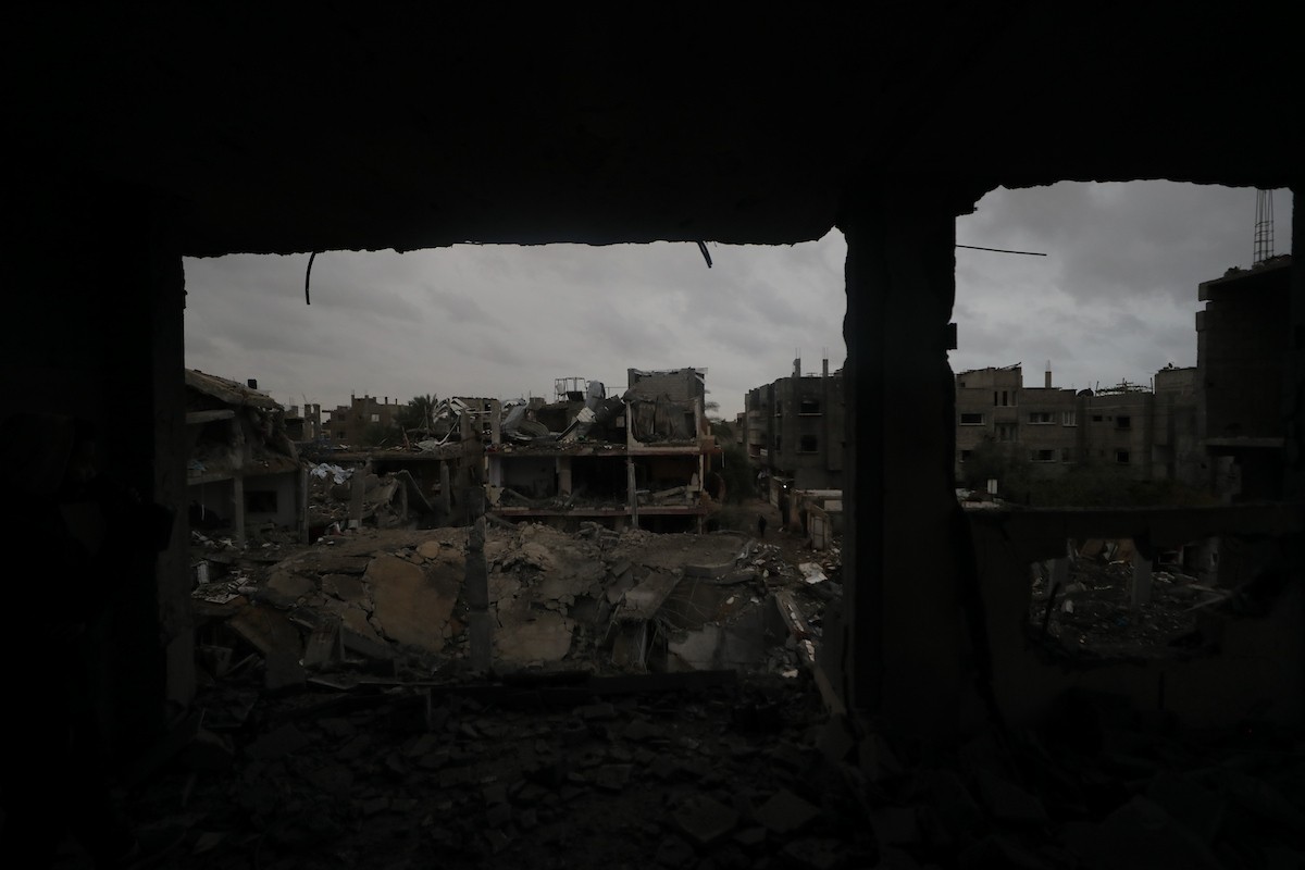 يبحث فلسطينيون عن ممتلكاتهم بين الأنقاض بعد أن دمرت غارات جوية إسرائيلية مبنى في مخيم البريج للاجئين وسط قطاع غزة. دمر الهجوم المبنى بالكامل وألحق أضرارًا بالمنشآت المحيطة به، 9 يناير/كانون الثاني 2026. صورة: معز صالحي