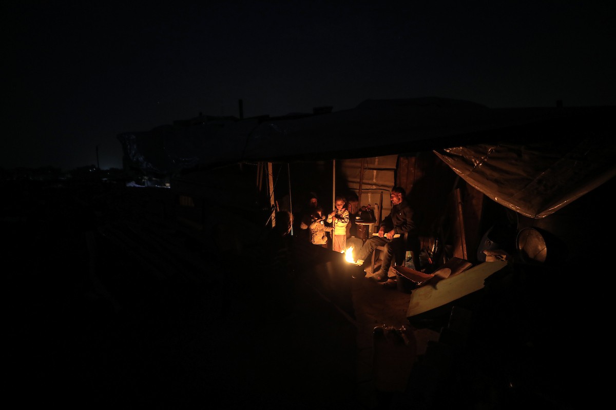 عائلات تعيش في خيام مؤقتة وسط الأنقاض تشعل نيرانًا للتدفئة في جباليا، شمال قطاع غزة، في 12 يناير/كانون الثاني 2026. ويكافح الفلسطينيون الذين دُمرت منازلهم في هجمات إسرائيلية من أجل البقاء في ظل ظروف شتوية قاسية وبرد قارس. صورة: عمر أشتوي