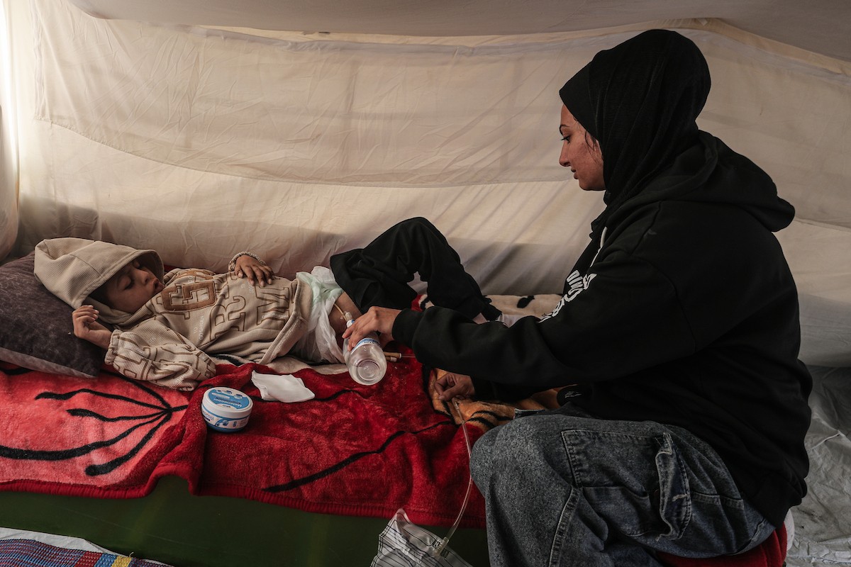 الطفل سيف رامي حجازي (13 عاما) أُصيب بشلل كامل وفشل كلوي إثر قصف إسرائيلي لخيمة عائلته، وتتولى والدته رعايته في ظروف إنسانية بالغة الصعوبة بمخيم المغازي، وسط قطاع غزة، 30 يناير/كانون الثاني 2026. صورة: معز صالحي