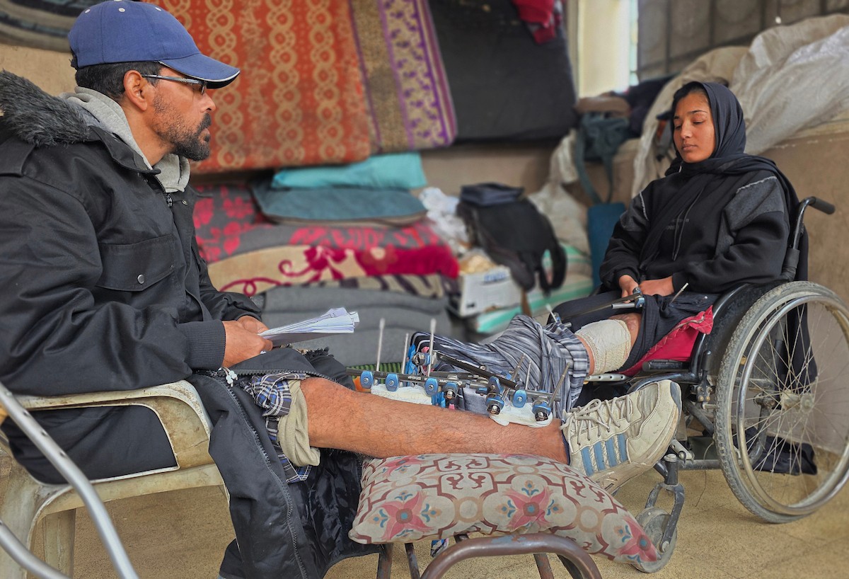 ريماس أبو لحية ووالدها مصابان بساقيهما برصاص الجيش الإسرائيلي، وينتظران السفر لاستكمال العلاج خارج قطاع غزة، خان يونس، 25 يناير/كانون الثاني 2026. تصوير: طارق محمد/ (APA Images)