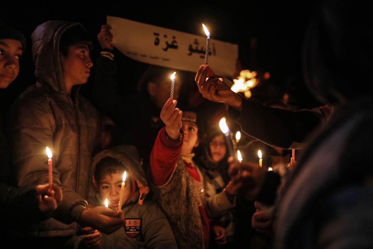 أطفال في وقفة احتجاجية في مخيم الشاطئ غرب مدينة غزة ليلة رأس السنة الميلادية 2026، 1 يناير/كانون الثاني 2026. تصوير: عمر أشتوي