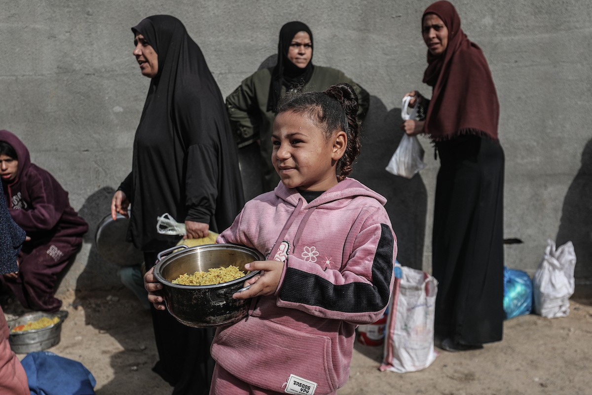 أطفال فلسطينيون ينتظرون وجبة ساخنة، توزعها إحدى المنظمات الخيرية، في ظل استمرار أزمة الغذاء بسبب محدودية المساعدات الإنسانية في مخيم النصيرات للاجئين وسط قطاع غزة، في 10 يناير/كانون الثاني 2026. صورة: معز صالحي