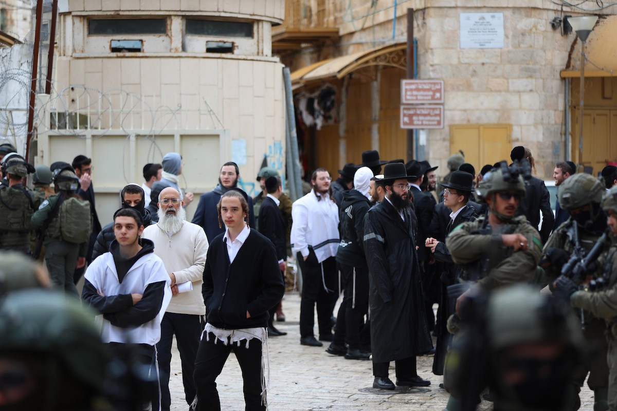 جنود إسرائيليون يقفون في دورية حراسة خلال جولة أسبوعية للمستوطنين في مدينة الخليل، جنوب الضفة الغربية ، 10 يناير/كانون الثاني 2026. تصوير: مأمون وزواز