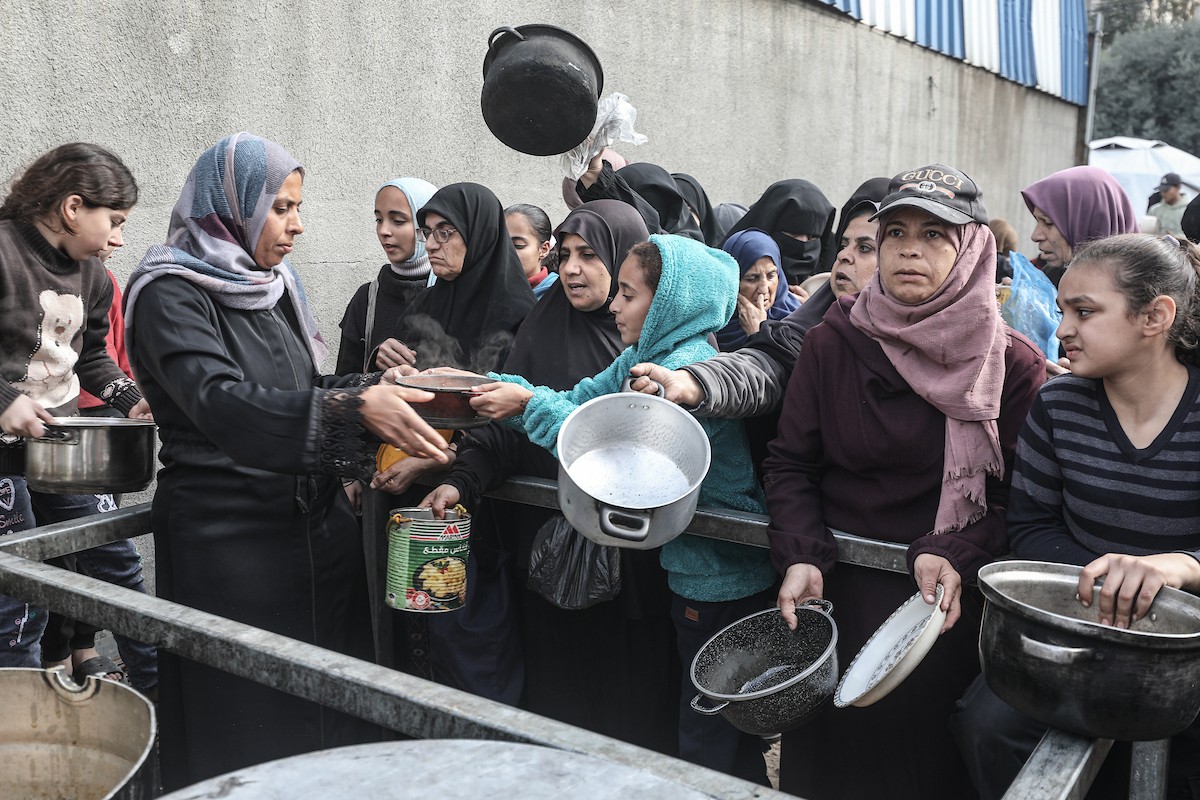 تلقى فلسطينيون، بينهم أطفال، وجبات ساخنة وزعتها إحدى الجمعيات الخيرية في مخيم النصيرات للاجئين، وسط نقص حاد في الغذاء ناجم عن الهجمات الإسرائيلية المستمرة وتدهور الأوضاع الإنسانية. النصيرات، وسط قطاع غزة. 26 يناير/كانون الثاني 2026. تصوير: معز صالحي