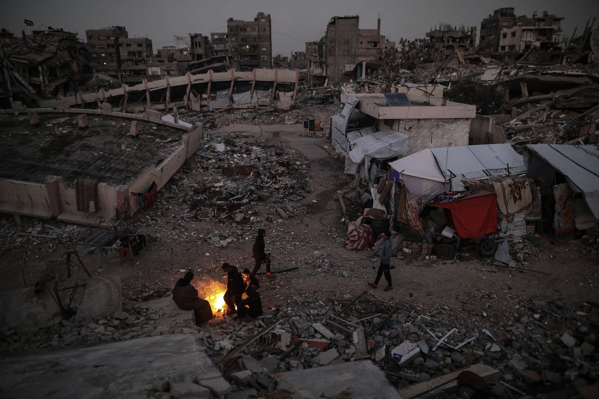 عائلات تعيش في خيام مؤقتة وسط الأنقاض تشعل نيرانًا للتدفئة في جباليا، شمال قطاع غزة، في 12 يناير/كانون الثاني 2026. ويكافح الفلسطينيون الذين دُمرت منازلهم في هجمات إسرائيلية من أجل البقاء في ظل ظروف شتوية قاسية وبرد قارس. صورة: عمر أشتوي