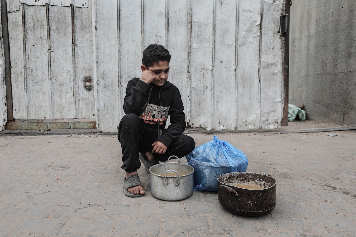 تلقى فلسطينيون، بينهم أطفال، وجبات ساخنة وزعتها إحدى الجمعيات الخيرية في مخيم النصيرات للاجئين، وسط نقص حاد في الغذاء ناجم عن الهجمات الإسرائيلية المستمرة وتدهور الأوضاع الإنسانية. النصيرات، وسط قطاع غزة. 26 يناير/كانون الثاني 2026. تصوير: معز صالحي