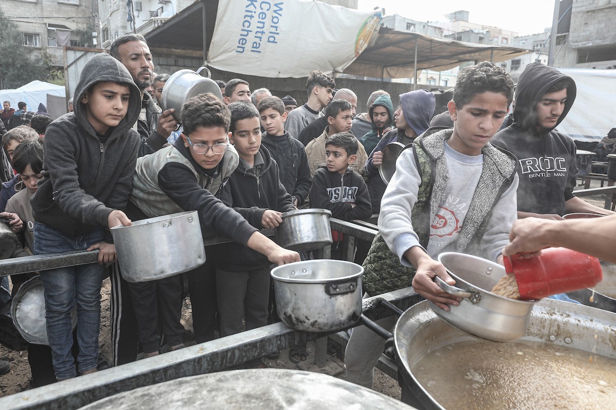تلقى فلسطينيون، بينهم أطفال، وجبات ساخنة وزعتها إحدى الجمعيات الخيرية في مخيم النصيرات للاجئين، وسط نقص حاد في الغذاء ناجم عن الهجمات الإسرائيلية المستمرة وتدهور الأوضاع الإنسانية. النصيرات، وسط قطاع غزة. 26 يناير/كانون الثاني 2026. تصوير: معز صالحي