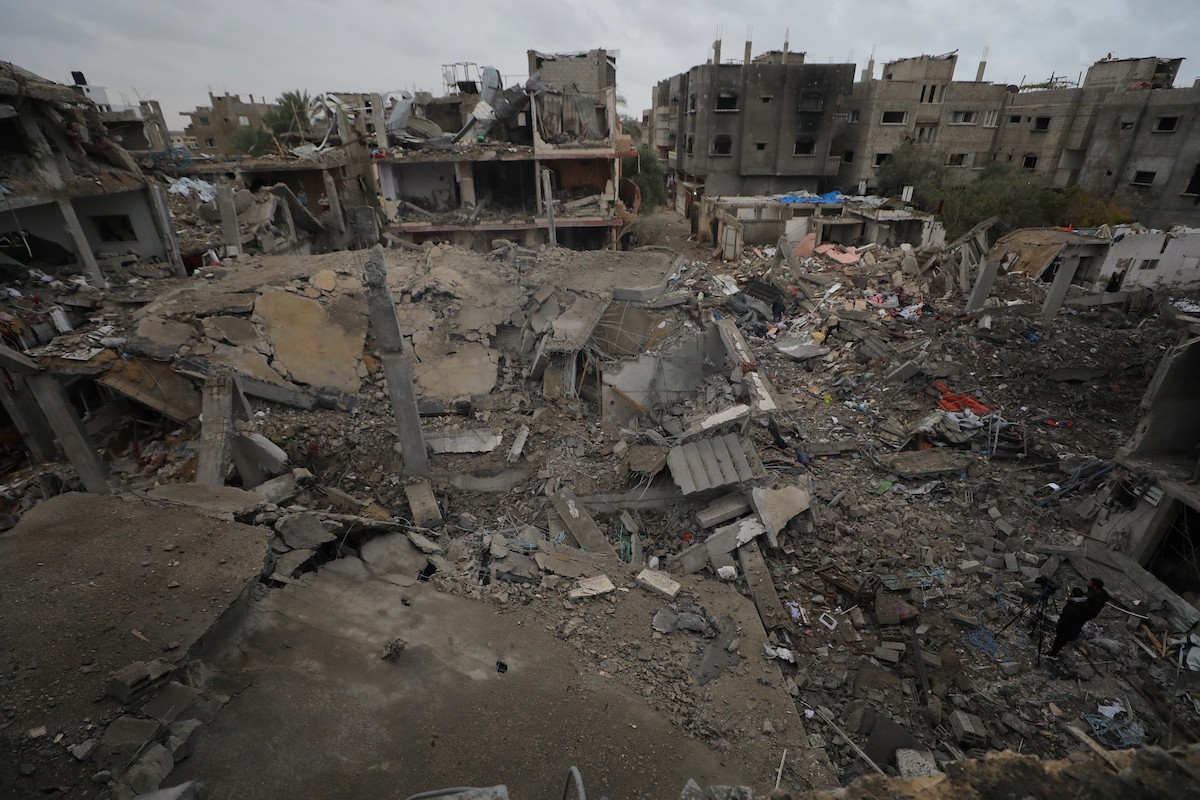 يبحث فلسطينيون عن ممتلكاتهم بين الأنقاض بعد أن دمرت غارات جوية إسرائيلية مبنى في مخيم البريج للاجئين وسط قطاع غزة. دمر الهجوم المبنى بالكامل وألحق أضرارًا بالمنشآت المحيطة به، 9 يناير/كانون الثاني 2026. صورة: معز صالحي