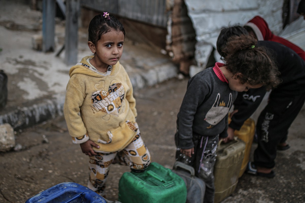 يملأ الفلسطينيون جالوناتهم بالمياه التي توزعها صهاريج المياه، وينقلونها إلى خيامهم في مخيم النصيرات، حيث تفاقمت أزمة المياه نتيجة الأضرار الجسيمة التي لحقت بالبنية التحتية جراء الهجمات الإسرائيلية. النصيرات، وسط قطاع غزة، 29 يناير/كانون الثاني 2026. صورة: رمزي أبو عامر