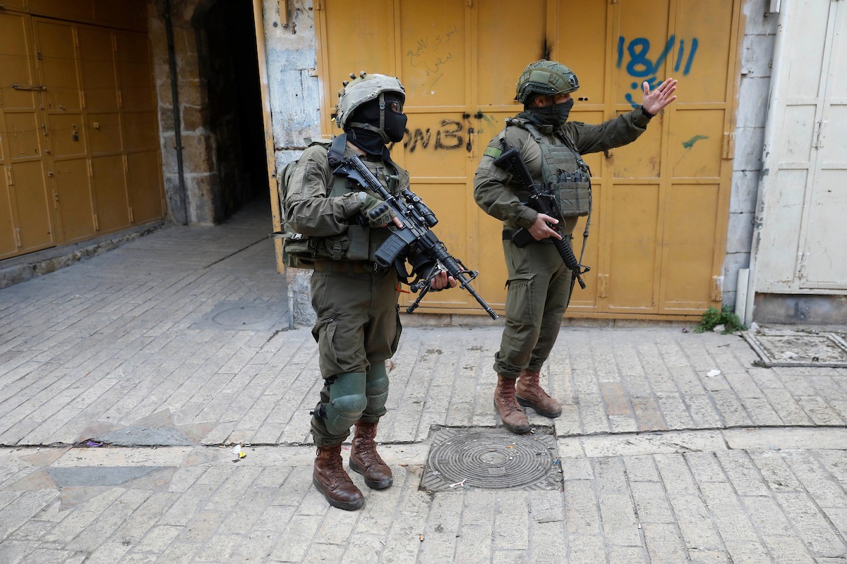 جنود إسرائيليون يتخذون إجراءات أمنية مشددة بإغلاق مداخل ومخارج منطقة البلدة القديمة في الخليل، الضفة الغربية، في 24 يناير/كانون الثاني 2026، خلال اقتحام  مستوطنون يهود البلدة(صورة: مأمون وزواز)