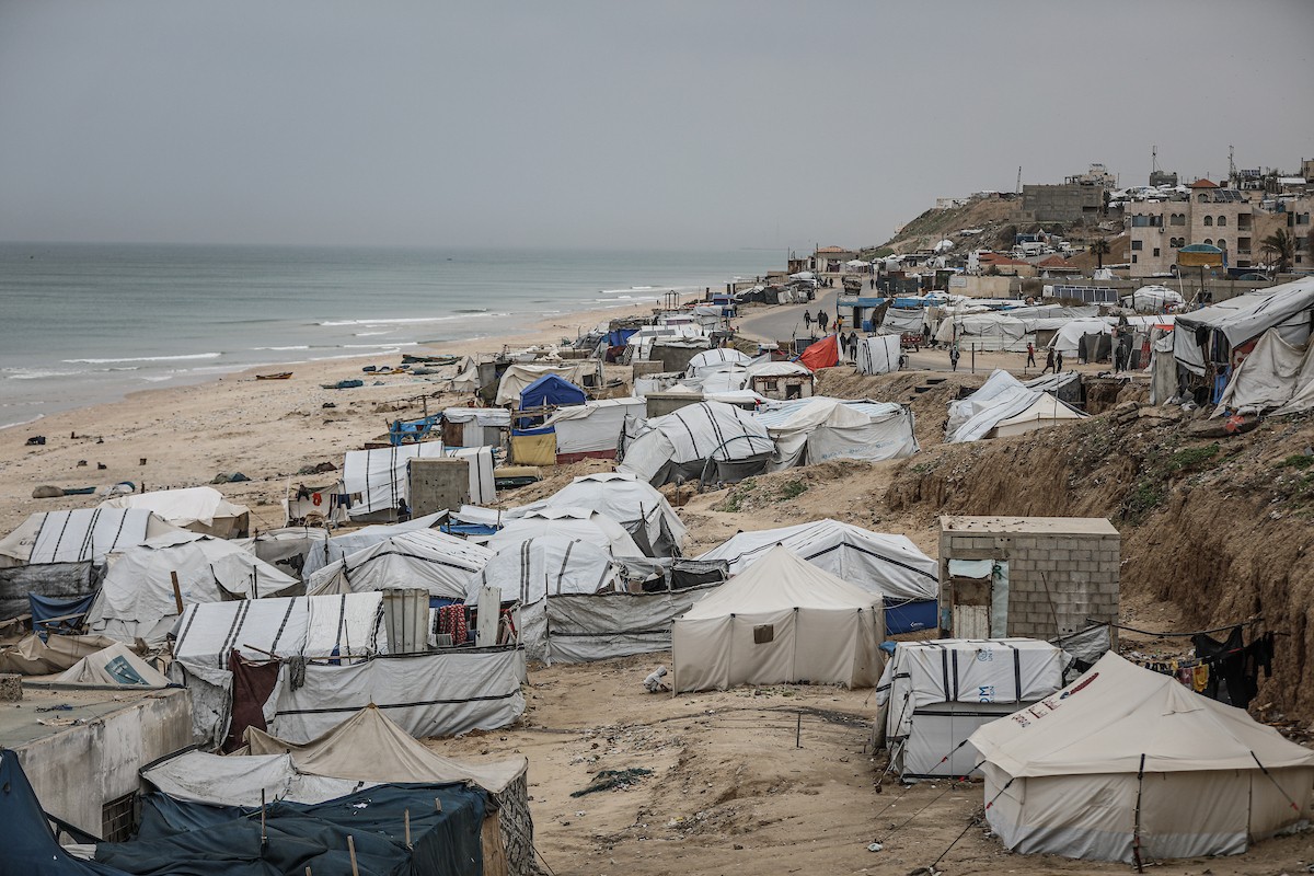 يتفقد فلسطينيون نازحون خيامهم بعد أن تضررت بشدة جراء عاصفة هوائية قوية ضربت مخيمًا للنازحين وسط قطاع غزة. 22 يناير/كانون الثاني 2026. تصوير: رمزي أبو عامر