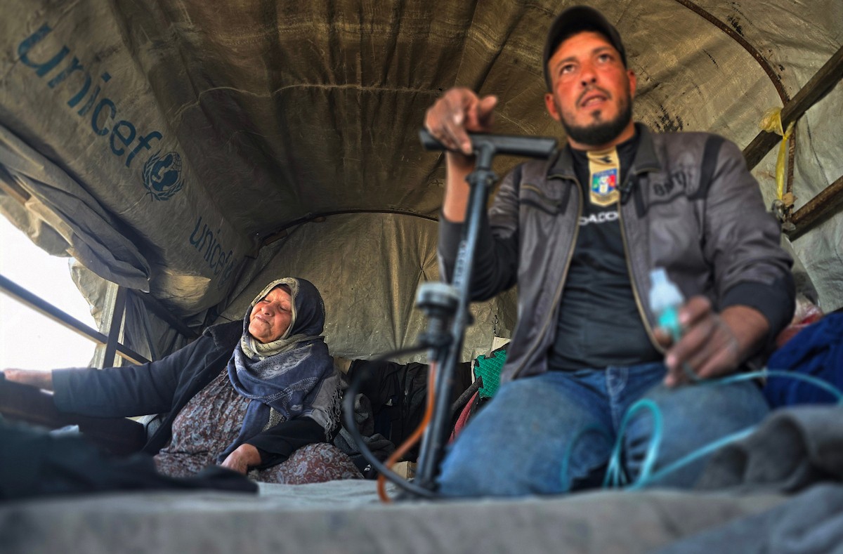يعيش الفلسطيني سامي أبو سعادة مع والدته داخل عربة جرار، ويستخدم مضخة نفخ مطاطية لمساعدة والدته التي تعاني من صعوبة في التنفس. خان يونس، جنوب قطاع غزة، 7 يناير/كانون الثاني 2026، صورة: طارق محمد