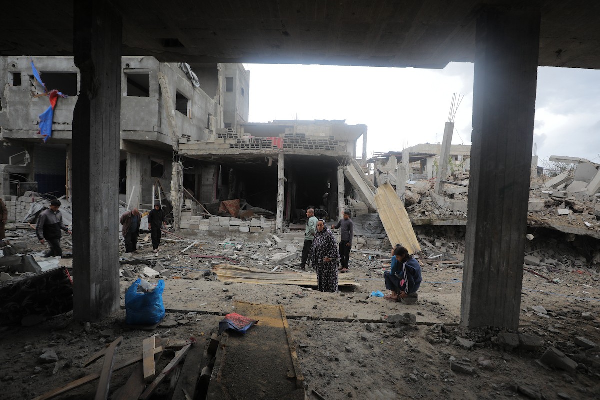 يبحث فلسطينيون عن ممتلكاتهم بين الأنقاض بعد أن دمرت غارات جوية إسرائيلية مبنى في مخيم البريج للاجئين وسط قطاع غزة. دمر الهجوم المبنى بالكامل وألحق أضرارًا بالمنشآت المحيطة به، 9 يناير/كانون الثاني 2026. صورة: معز صالحي