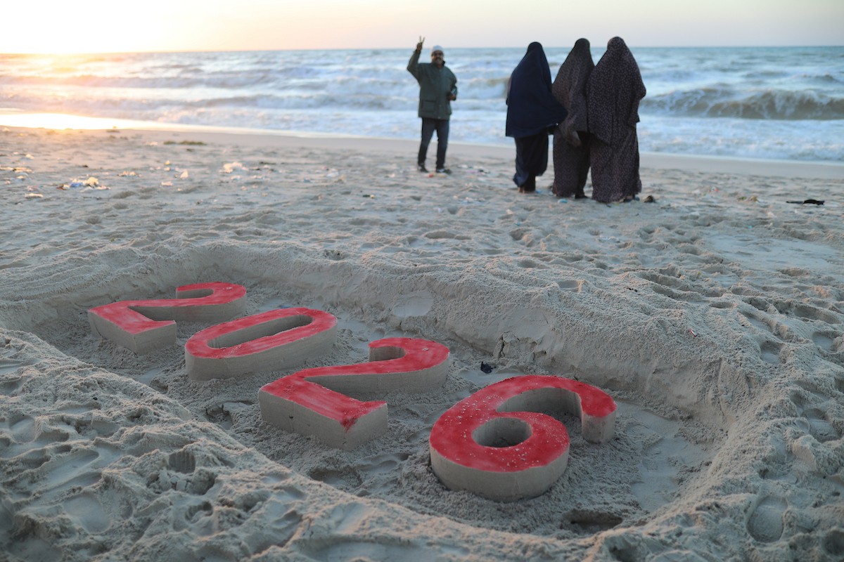 فلسطينيون يودعون عام 2025 بكتابة 2026 على رمال شاطئ غزة، 31 ديسمبركانون الأول 2025. صورة عمر أشتوي