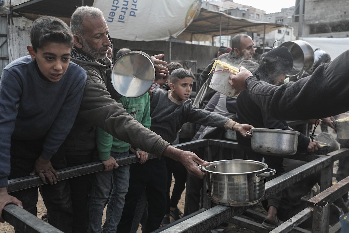 تجمع فلسطينيون نازحون داخلياً في مطبخ خيري لتلقي حصص غذائية محدودة وسط نقص حاد في الغذاء، في مخيم النصيرات للاجئين وسط قطاع غزة، 21 يناير/كانون الثاني 2026. صورة: معز صالحي
