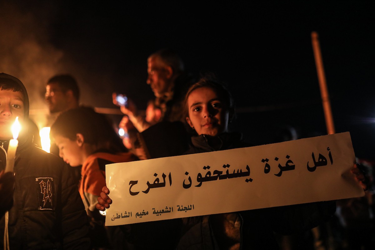 أطفال في وقفة احتجاجية في مخيم الشاطئ غرب مدينة غزة ليلة رأس السنة الميلادية 2026، 1 يناير/كانون الثاني 2026. تصوير: عمر أشتوي