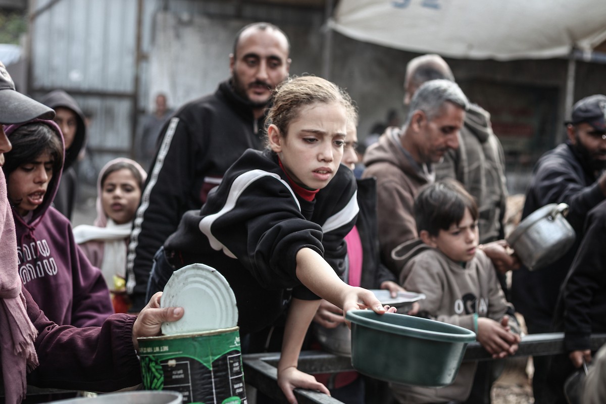 تلقى فلسطينيون، بينهم أطفال، وجبات ساخنة وزعتها إحدى الجمعيات الخيرية في مخيم النصيرات للاجئين، وسط نقص حاد في الغذاء ناجم عن الهجمات الإسرائيلية المستمرة وتدهور الأوضاع الإنسانية. النصيرات، وسط قطاع غزة. 26 يناير/كانون الثاني 2026. تصوير: معز صالحي