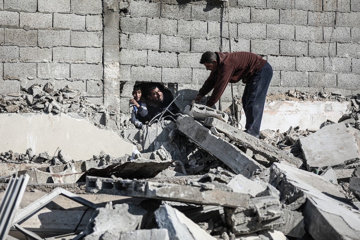 فلسطينيون يتفقدون منزلاً (تضرر سابقاً جراء غارة جوية إسرائيلية) انهار على سكانه، ما أسفر عن وفاة رجل ونجله الصغير في مخيم المغازي للاجئين وسط قطاع غزة، 5 يناير/كانون الثاني 2026. صورة: رمزي أبو عامر