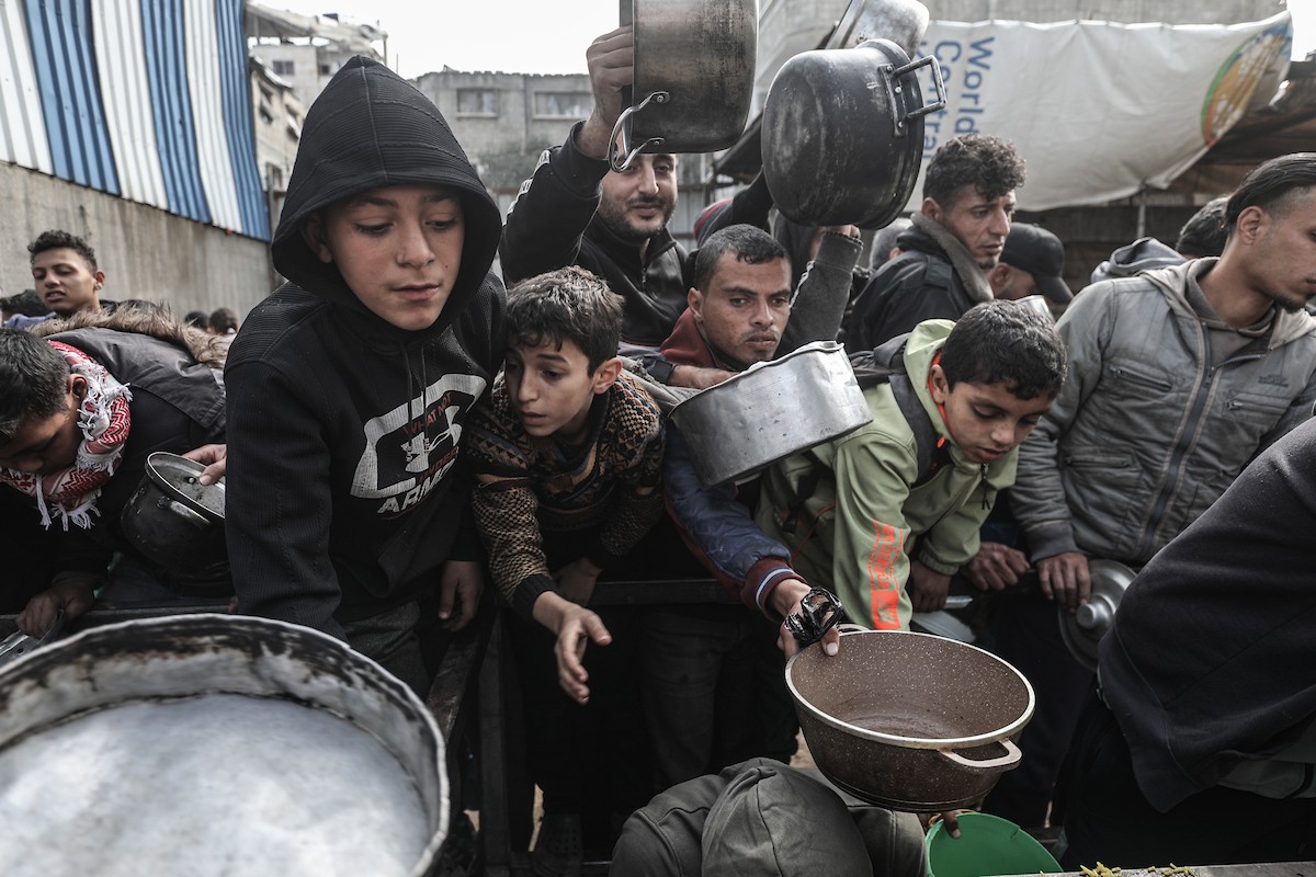 تجمع فلسطينيون نازحون داخلياً في مطبخ خيري لتلقي حصص غذائية محدودة وسط نقص حاد في الغذاء، في مخيم النصيرات للاجئين وسط قطاع غزة، 21 يناير/كانون الثاني 2026. صورة: معز صالحي