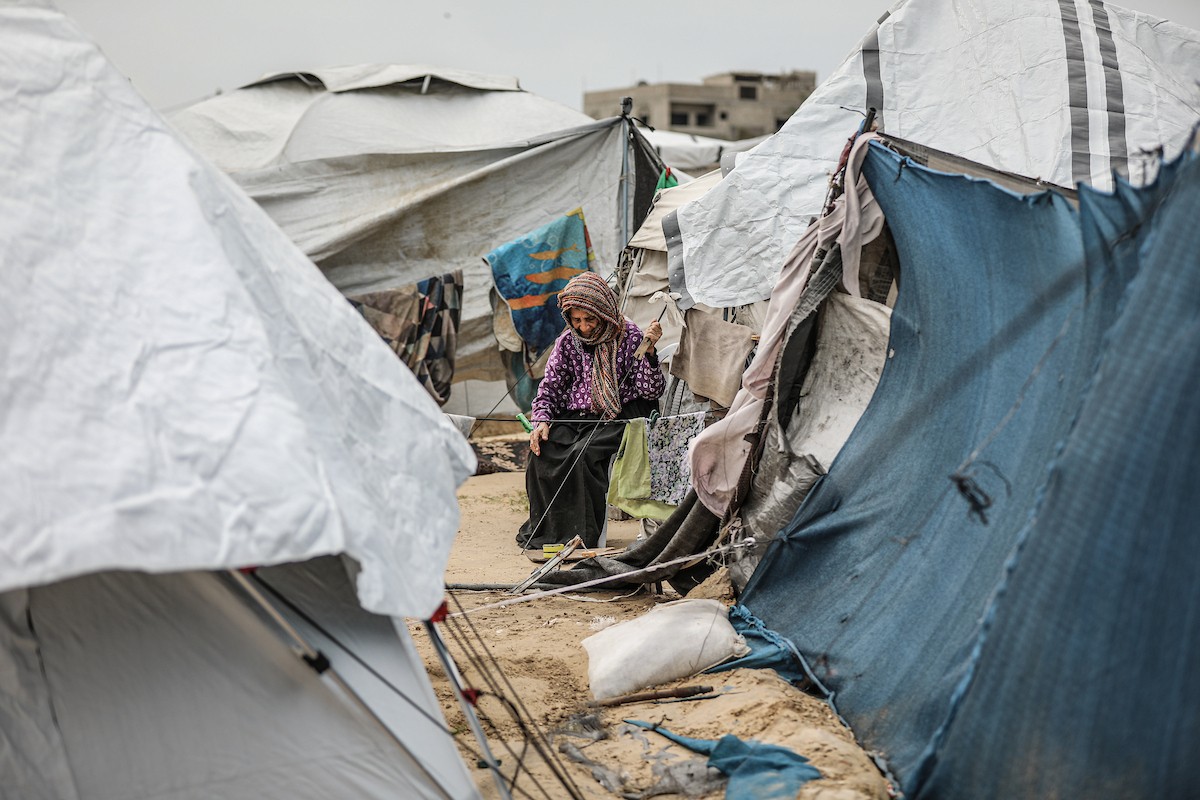 يتفقد فلسطينيون نازحون خيامهم بعد أن تضررت بشدة جراء عاصفة هوائية قوية ضربت مخيمًا للنازحين وسط قطاع غزة. 22 يناير/كانون الثاني 2026. تصوير: رمزي أبو عامر