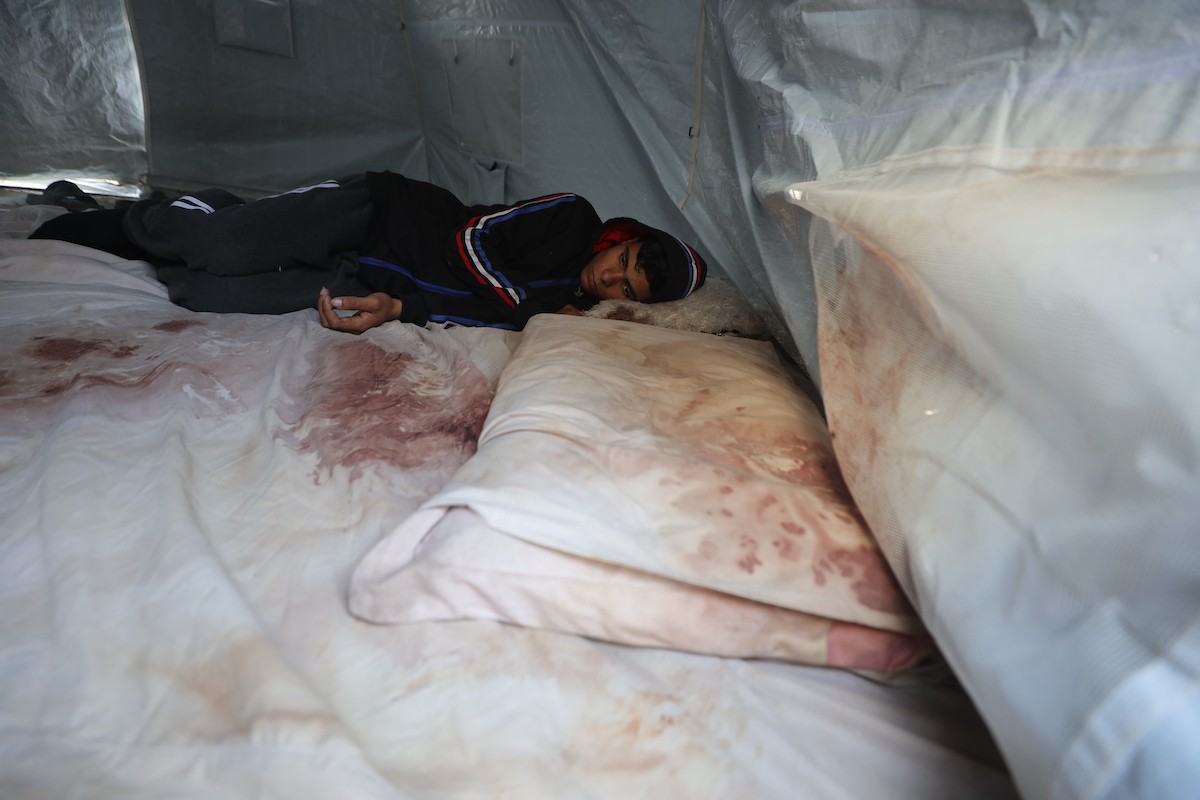 يكافح الشاب الفلسطيني أحمد أبو سعادة، البالغ من العمر عشرين عامًا، من أجل البقاء في خيمة مؤقتة بعد أن فقد زوجته، ولاء جحا، بعد ثلاثة أيام فقط من زفافهما، إثر غارة جوية إسرائيلية على غزة، 7 يناير/كانون الثاني 2025. صورة: عمر أشتوي