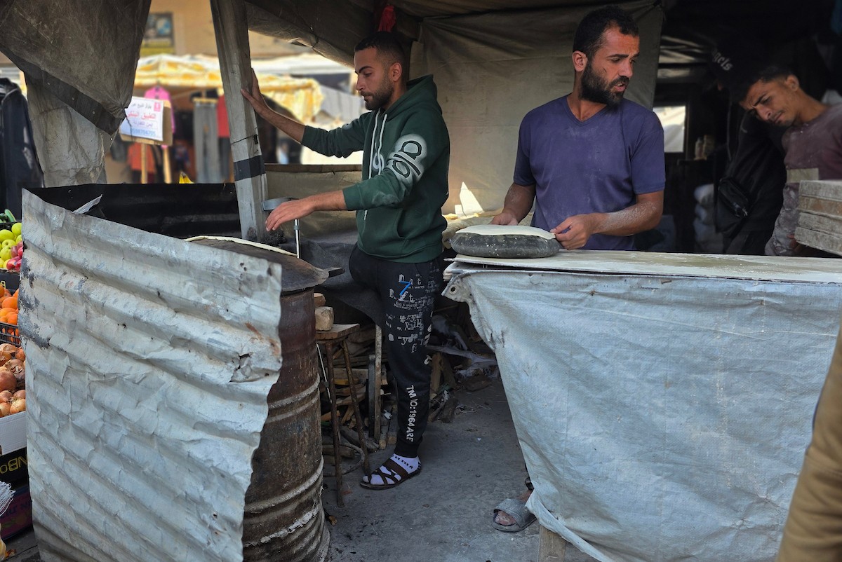 الفلسطيني محمد قحمان يعيد افتتاح مخبز تقليدي وسط أنقاض مدينة حمد غرب خان يونس، ويعمل جنباً إلى جنب مع أبنائه وصهره، وجميعهم من مبتوري الأطراف، 21 يناير/كانون الثاني 2026  . صورة: طارق محمد