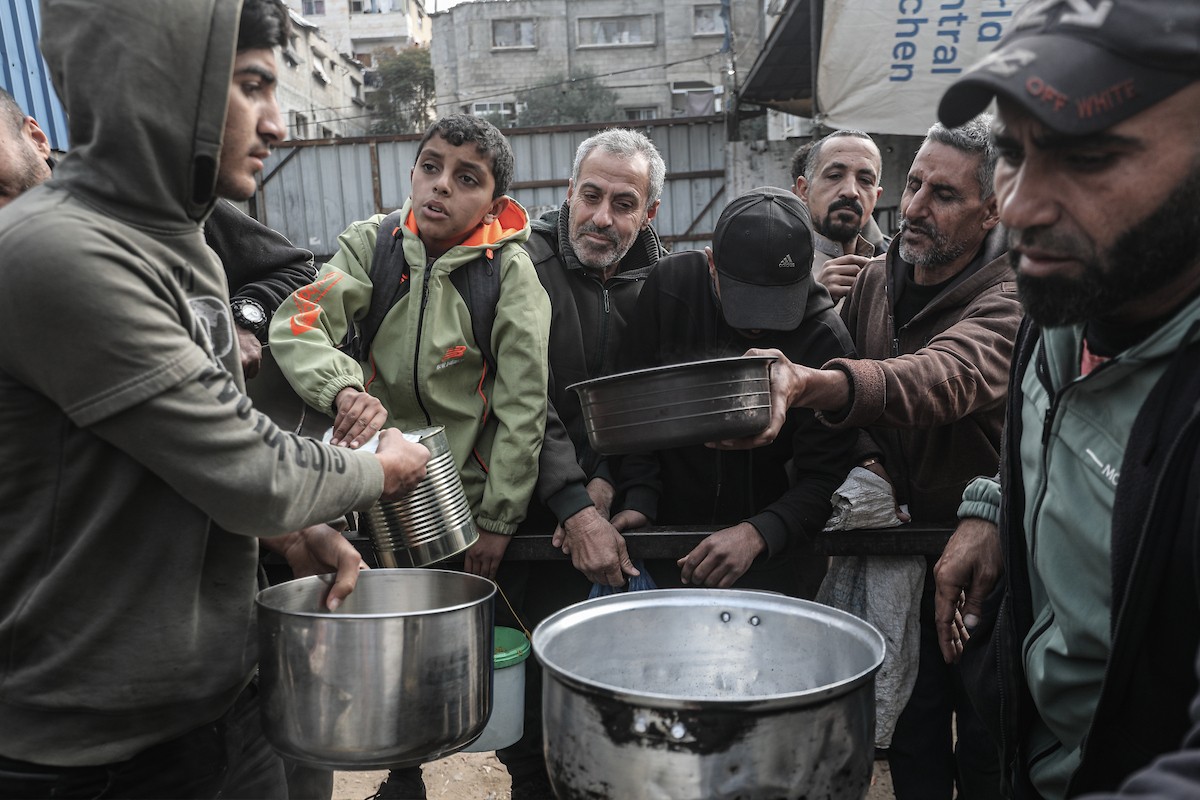 تجمع فلسطينيون نازحون داخلياً في مطبخ خيري لتلقي حصص غذائية محدودة وسط نقص حاد في الغذاء، في مخيم النصيرات للاجئين وسط قطاع غزة، 21 يناير/كانون الثاني 2026. صورة: معز صالحي