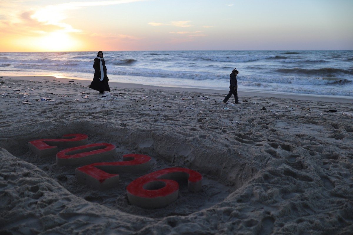 فلسطينيون يودعون عام 2025 بكتابة 2026 على رمال شاطئ غزة، 31 ديسمبركانون الأول 2025. صورة عمر أشتوي